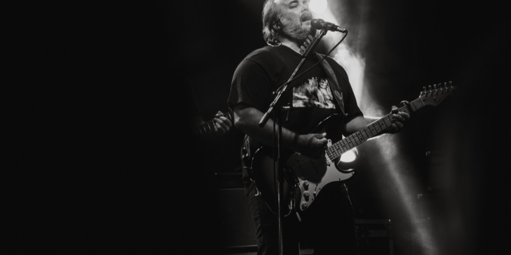 Christian Cary cantando y tocando la guitarra en vivo