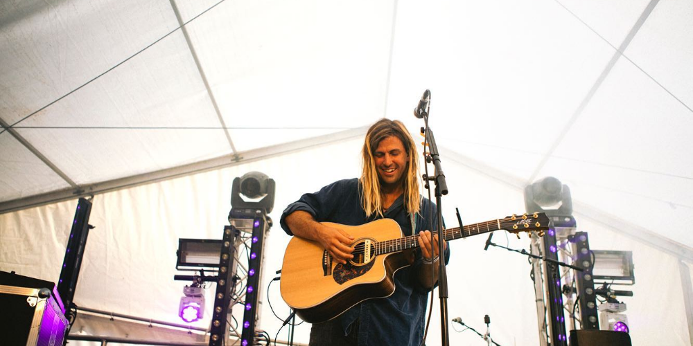 Imagen de Felipe Baldomir sonriendo y tocando su guitarra en un concierto