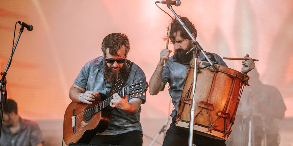 Los integrantes de Los Tabaleros desplegando su energía en pleno concierto, fusionando la pasión del rock y la esencia del folclore en una performance vibrante